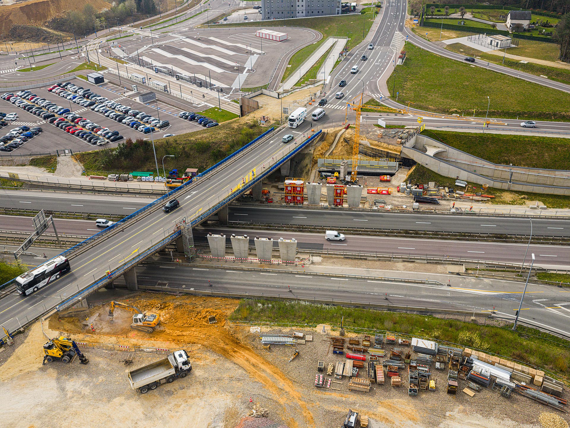 Aerial view of the construction site for the new bridge over the A1 motorway at Findel, showing eight concrete piers next to the existing bridge.