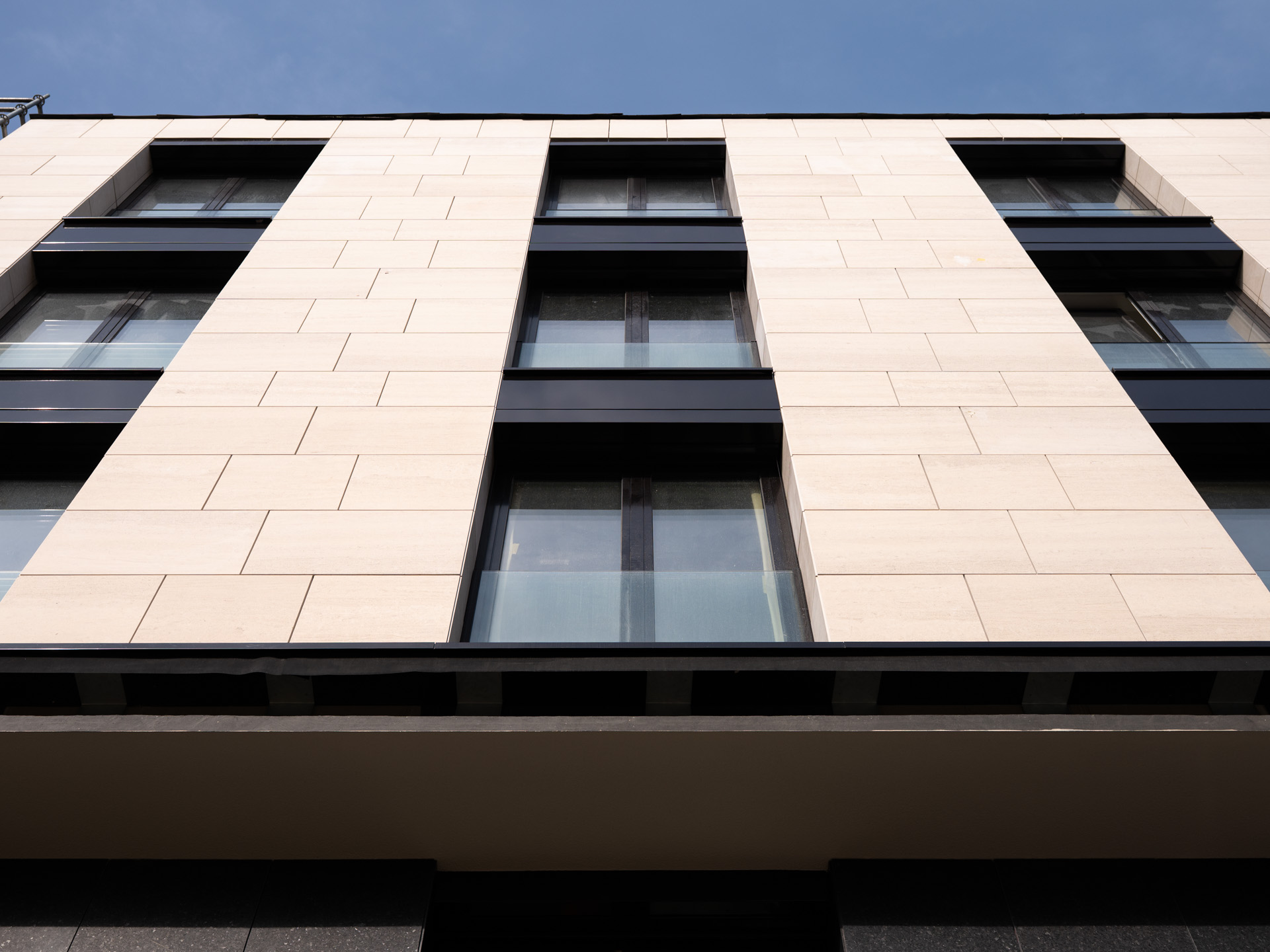 Une façade contemporaine sublimée par le contraste entre la pierre Moca Crème et les touches foncées du Néro Angola.